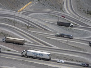 Heavy traffic of trucks on mountain pass Los Caracoles, The Snails, road connecting Chile and