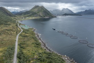 Aerial view of a salmon farm, rainy weather, grey sky, village Myre in the back, Vesteralen