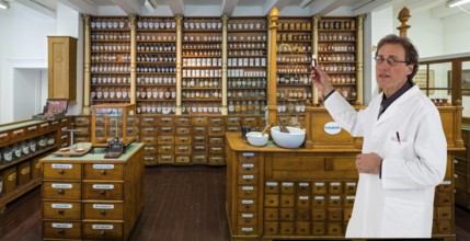 Historic pharmacy with pharmacist and bottle in hand