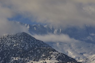 Snow-covered mountain peaks under a slightly cloudy sky, Lefka Ori, White Mountains, mountain