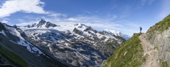 Mountaineer on a hiking trail, view of high alpine mountain landscape, summit of Aiguille de