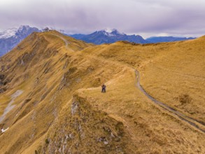 A couple stands on a hill path with far-reaching mountain views, Alpen Tower, Switzerland, Europe