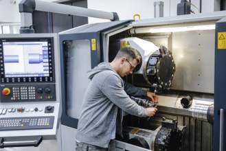 Remscheid, North Rhine-Westphalia, Germany - Trainee in metalworking, here at a CNC machine tool,