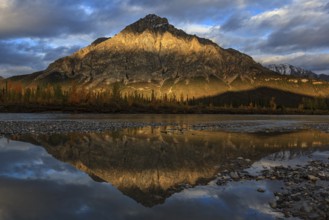 Clouds and evening light over mountains, mountain reflected in water, autumn, Brooks Range, Alaska,