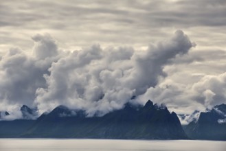 Mystical landscape with dramatic mountain peaks and clouds over the sea, Norway, Europe
