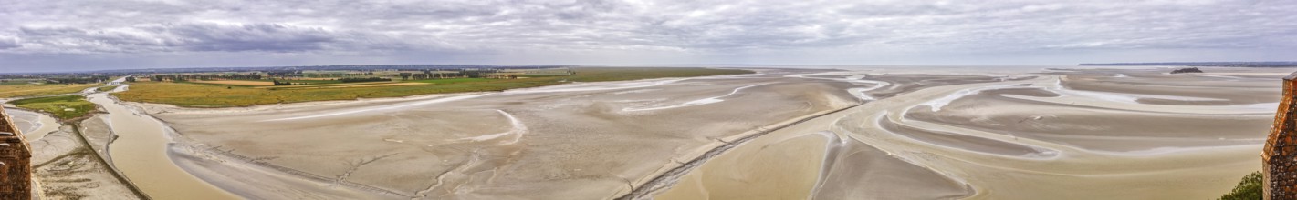 Expansive panorama with sand, watercourses and a wide horizon under a cloudy sky, Le