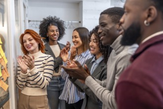 Diverse teamwork applauding at the end of a brainstorming meeting in a coworking space
