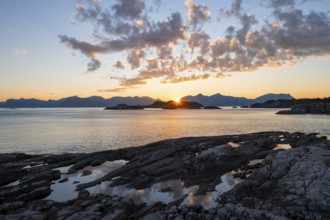 Clouds reflected in a small pond on a rocky coast, coastal landscape at sunset, Henningsvær,