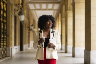 Elegant african american businesswoman walking in the city street in the morning