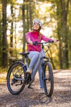 Woman on Ebike through the autumn forest, Black Forest, Gechingen, Germany, Europe