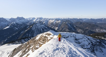 Ski tourers at the summit of Schafreuter, view of snow-covered mountain panorama, Karwendel, Tyrol,