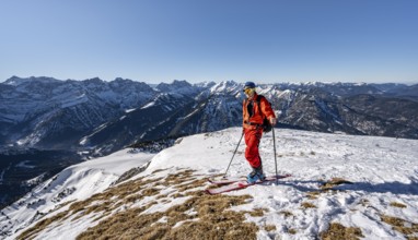 Ski tourers at the summit of Schafreuter, view of snowy mountain panorama, Karwendel, Tyrol,