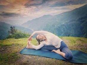 Yoga outdoors, young sporty fit woman doing Hatha Yoga asana janu sirsasana, Revolved Head-to-Knee