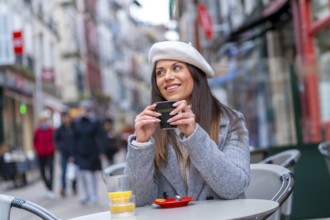 French style woman smiling looking away sitting in an outdoor cafeteria