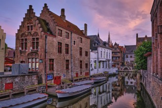 Bruges Rozenhoedkaai old houses along canal with tree in the evening. Famous place of Brugge,