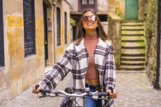 Pretty latin woman with sunglasses doing bicycle sightseeing in the city through the old town. Eco