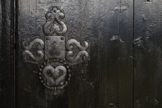 Ornate wooden door with wrought-iron, richly decorated fittings, backdrop Kristin Lavranstochter