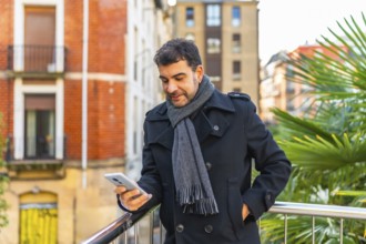 Three quarter length portrait of a caucasian adult casual businessman using phone standing in a