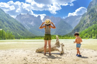 Mother and son enjoying a sunny day at lago di landro, surrounded by the stunning dolomites in
