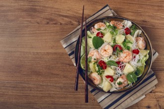 Thai salad with shrimp and rice noodles, pineapple slices, coriander and mint leaves, homemade, no