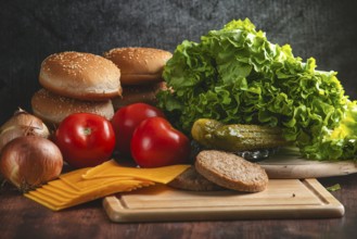 Fresh ingredients for a hamburger, such as lettuce, tomatoes, cheese and bun