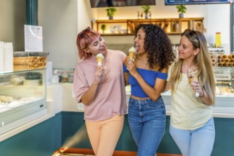 Three diverse female friends eating delicious ice cream in a shopping mall