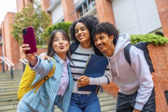 Low angle view portrait of thee multi-etnic cool university students taking a selfie in the campus