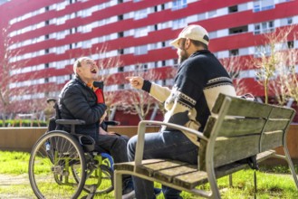 Two men enjoying time together in urban park, one using wheelchair, demonstrating inclusion and