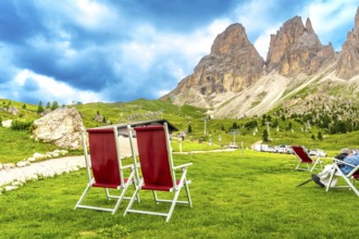 Red deckchairs inviting tourists to relax and enjoy the breathtaking view of the sassolungo