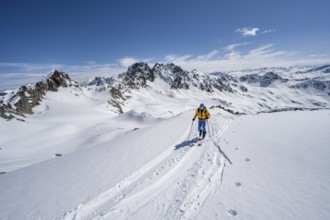 Two ski tourers in mountain landscape with snow, view of peaks Piz Grialetsch and Piz Vadret,