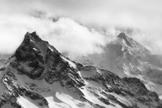 Fog envelops the snowy summit of the mountain Le Besso, Val d'Anniviers, Valais Alps, Canton