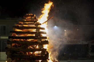 A large pile of wood burns brightly and is surrounded by flames, Easter bonfire Psinthos, Holy