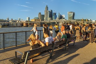 People enjoying the summer evening on the Thames near the Millenium Bridge, London, England, Great
