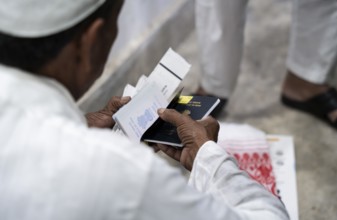 Hajj pilgrims check passport and documents before leaving to the airport, in Guwahati, India on 3