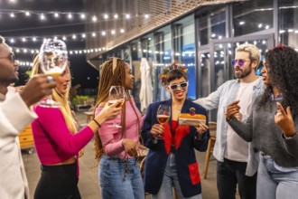 Multi-ethnic friends surprising woman with birthday cake at bar terrace at night