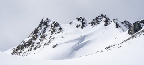 Minimalist winter landscape, white snow and dark mountains on the Scalettahorn, Graubünden,