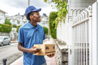 Delivery man using mobile to check the location holding a parcel