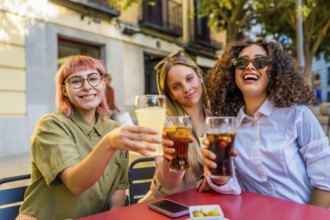 Three happy diverse women gesturing success while taking selfie with camera at bar