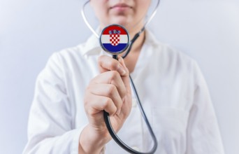 Female doctor holding stethoscope with Croatian flag. National health system of Croatia