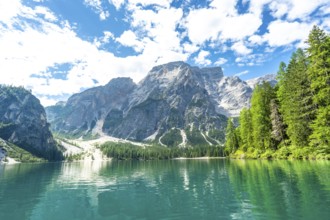 Emerald waters reflecting the majestic dolomites peaks at lake braies, a stunning natural wonder in