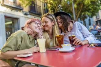 Multi-ethnic female friends reunited drinking beverages on an outdoor bar