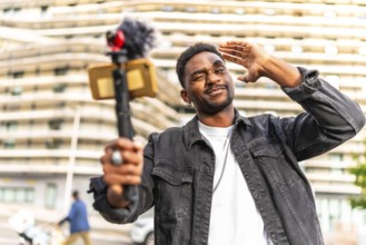 African man vlogger gesturing and winking while streaming online in the city