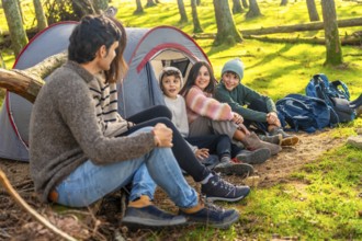 Caucasian family with three child enjoying a weekend camping in the forest together