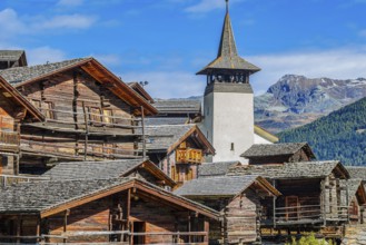 Old wooden houses and the Saint Theodule church in the historic village centre, Grimentz, Val