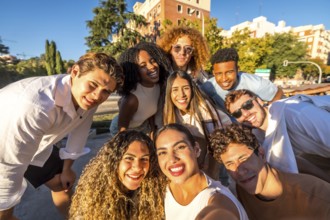 Frontal view of a group of diverse young people taking selfie in the street smiling at camera