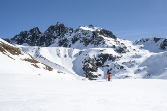 Ski tourers on the Graubünden Haute Route in the Val Susauna mountain valley, snow-covered