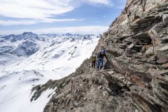 Two mountaineers climbing up a narrow mountain path, ascent to the summit of Piz Grialetsch in