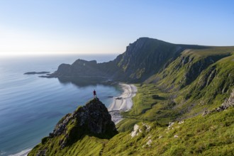 Climber on a rock, view of picturesque coastal landscape, steep coast with peak Måtind or Måtinden,