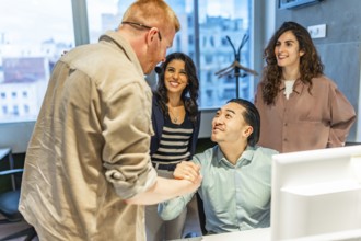 Business team congratulating their colleague on a successful project, shaking hands in the office