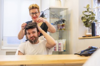 Reflection on the mirror of a modern hairdresser and satisfied man with new capillary prosthesis in